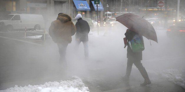Pedestrians make their way around lower Manhattan on slushy morning in New York, Monday, Feb. 2, 2015. New York City Mayor Bill de Blasio is warning commuters to be