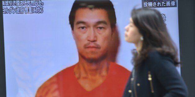 A pedestrian walks past a TV screen in Tokyo on January 26, 2015 showing news reports about Japanese journalist Kenji Goto being held by Islamic militants. The Islamic State group has said it executed one of two Japanese hostages it has been holding, in an apparent beheading that has been slammed by leaders around the world. AFP PHOTO / KAZUHIRO NOGI (Photo credit should read KAZUHIRO NOGI/AFP/Getty Images)