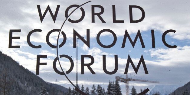 The logo of the World Economic Forum is pictured through a window in Davos, Switzerland, Tuesday, Jan. 20, 2015. The world's financial and political elite will head this week to the Swiss Alps for 2015's gathering of the World Economic Forum at the Swiss ski resort of Davos. (AP Photo/Michel Euler)