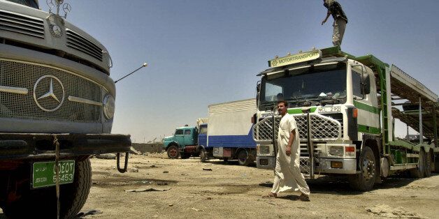 Foreign truck drivers go about their day and prepare to take on the road in a truck yard in Baghdad, Iraq Tuesday 27, 2004. A growing number of foreign truck drivers whose cargo is vital to Iraq's reconstruction efforts are refusing to brave the gauntlet of kidnappings, robberies and other violence plaguing the country, with militants now threatening to cut the highway to Jordan. (AP Photo/Khalid Mohammed)
