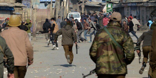Indian police chase away Kashmiri supporters of the Jammu and Kashmir Liberation Front (JKLF) during a protest in Srinagar on January 16, 2015. JKLF Chairman Mohammad Yasin Malik and supporters were demonstrating against a reported decision by the Indian government to give permanent resident status to refugees of Bangladesh, formerly West Pakistan, who are settled in various areas of the winter capital of restive Kashmir. AFP PHOTO/Rouf BHAT (Photo credit should read ROUF BHAT/AFP/Getty Images)