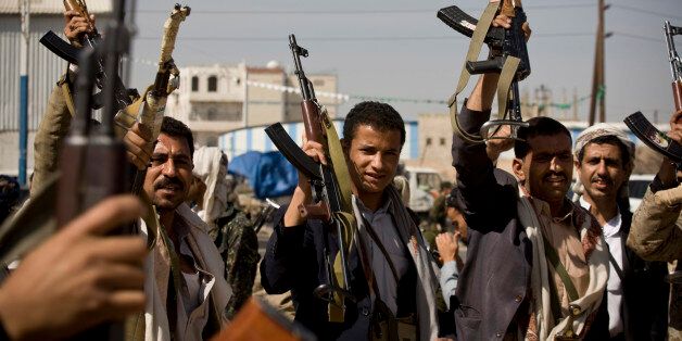Houthi Shiite Yemeni hold their weapons during clashes in near the presidential palace in Sanaa, Yemen, Monday, Jan. 19, 2015. Rebel Shiite Houthis battled soldiers near Yemen's presidential palace and elsewhere across the capital Monday, despite a claim of a cease-fire being reached to halt the violence, witnesses and officials said. (AP Photo/Hani Mohammed)