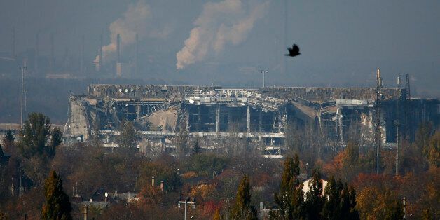 The normally functioning Avdeyevsky chemical plant is seen behind the main terminal of Donetsk Sergey Prokofiev International Airport hit by shelling during artillery battles between pro-Russian rebels and Ukrainian government forces in the town of Donetsk, eastern Ukraine Friday, Oct. 17, 2014. Ukraine's president on Friday hailed progress in Europe-brokered talks aimed at ensuring peace with Russia, with agreements nearing on a gas dispute and local elections in the east. (AP Photo/Dmitry Love
