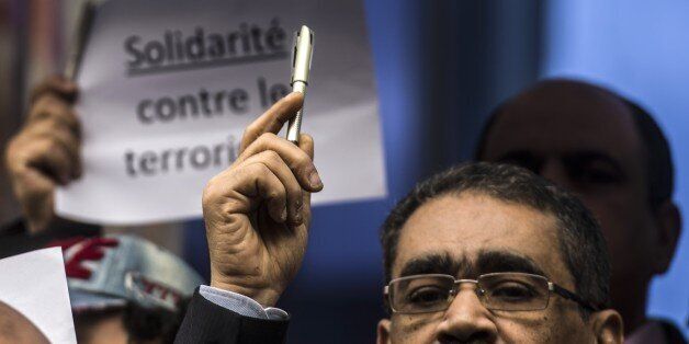 Egyptian journalists hold up pens in a silent protest outside Egypts syndicate of Journalists in Cairo on January 11, 2015, to protest against the attack on the French satirical magazine Charlie Hebdo's office in Paris which killed 12 people. More than a million people and dozens of world leaders were expected to march through Paris in a historic display of global defiance against extremism after Islamist attacks that left 17 dead. AFP PHOTO/ KHALED DESOUKI (Photo credit should read KHALE