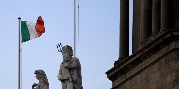 The Irish flag and the European Union flag outside the custom house building in Dublin city centre, Ireland, Friday, Dec. 13, 2013. On Sunday, Ireland officially ends its reliance on a 67.5 billion-euro ($93 billion) loan program that European governments and the International Monetary Fund provided in 2010 to save the Irish from national bankruptcy. Ireland's finance chief says the country's exit from its international bailout this week should be celebrated as a eurozone triumph, but won't mean an end to austerity for the debt-battered Irish. (AP Photo/Peter Morrison)