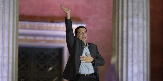 Leader of Syriza left-wing party Alexis Tsipras waves to his supporters outside Athens University Headquarters, Sunday, Jan. 25, 2015. Anti-bailout Syriza, led by the 40-year-old Alexis Tsipras, won Sunday's snap general election, but it was unclear whether he would have enough seats in parliament to form a government alone, or whether he would need the support of a smaller party. (AP Photo/Lefteris Pitarakis)