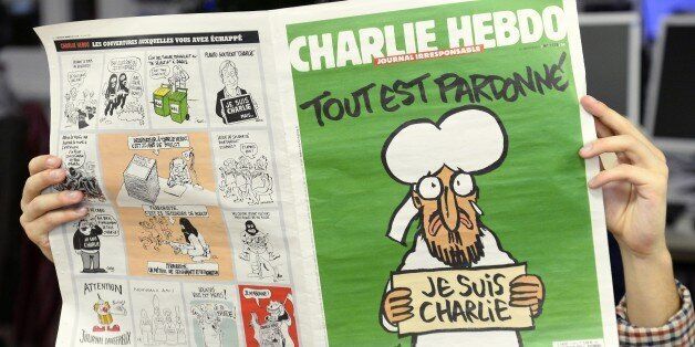 A man reads, in a newsroom in Paris, the last issue of French satirical weekly Charlie on January 13, 2015. A defiant Charlie Hebdo cover of a crying Prophet Mohammed above the slogan 'All is Forgiven' was reproduced by media around the world on January 13, its first since many of its staff were slain in a jihadi attack that killed 12 people on January 7. This week's post-attack edition of the French satirical magazine Charlie Hebdo will be made available in six languages including English, Arabic and Turkish. AFP PHOTO / BERTRAND GUAY (Photo credit should read BERTRAND GUAY/AFP/Getty Images)