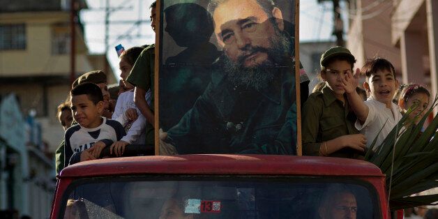 Children ride in the bed of a truck with a framed image of Fidel Castro, in Regla, Cuba, Thursday, Jan. 8, 2015, in a caravan tribute to the 56th anniversary of the original street party that greeted Castro and his rebel army in 1959. Castro and his rebels arrived in Havana via caravan, after toppling dictator Fulgencio Batista. The revolutionary leader and former president has not spoken publicly on the historic Dec. 17th US-Cuba detente. (AP Photo/Ramon Espinosa)