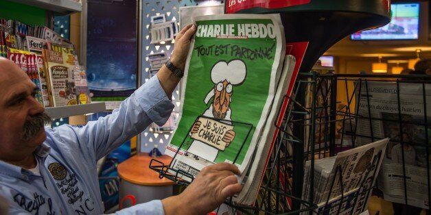 A man reads the latest edition of French satirical weekly Charlie Hebdo at a newsagents and cafe in Dunkirk on January 14, 2015 as the edition goes on sale. The latest edition of Charlie Hebdo since Islamist attacks on the magazines offices left 12 people dead, has sold out in many parts of France. AFP PHOTO / PHILIPPE HUGUEN (Photo credit should read PHILIPPE HUGUEN/AFP/Getty Images)