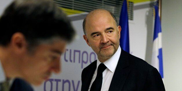 EU Commissioner for Economic and Financial Affairs Pierre Moscovici arrives at a news conference in Athens on Tuesday, Dec. 16, 2014. A refusal by Greece to repay bailout debts would be