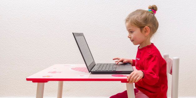 WUERZBURG, BAVARIA, GERMANY - 2014/12/21: A blond three year old girl is sitting in front of a notebook, laptop, watching the screen and using the keyboard. (Photo by Frank Bienewald/LightRocket via Getty Images)