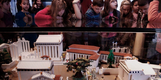 Schoolchildren look at a Lego model of the Acropolis in the new Acropolis Museum under the ancient citadel in Athens, Thursday, Dec. 11, 2014. The model, painstakingly built with 120,000 plastic bricks by Ryan McNaught, was donated to the Greek museum by the Nicholson Museum in Sydney, Australia. (AP Photo/Petros Giannakouris)