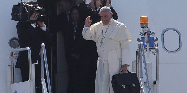 Pope Francis waves before boarding his plane as he departs Manila, Philippines on Monday, Jan. 19, 2015. Pope Francis flew out of this Catholic bastion in Asia on Monday after a weeklong trip that included a visit to Sri Lanka and drew what Filipino officials says was a record crowd of 6 million faithful in a Manila park where he celebrated Mass. (AP Photo/Aaron Favila)