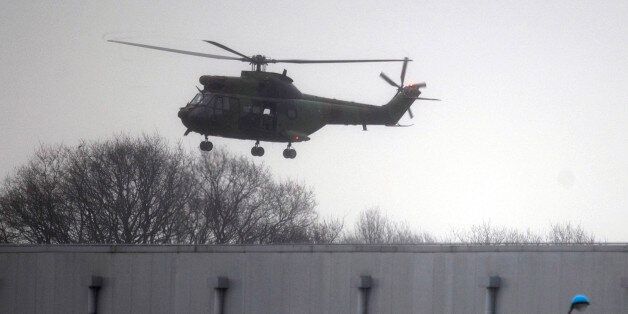 A military helicopter flies over Dammartin-en-Goele, northeast of Paris, Friday Jan. 9, 2015. Brothers suspected in a newspaper terror attack were cornered with a hostage inside a printing house on Friday, after they hijacked a car and police followed them to a village near Paris' main airport. (AP Photo/Peter Dejong)