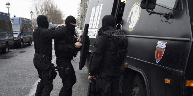 Members of the French national police intervention group (BRI) prepare their gears before leaving on operation in front of Paris' police headquarters on January 8, 2015, a day after Islamist gunmen stormed the office of satirical magazine Charlie Hebdo, killing eight journalists, two police and two others. The men are still thought to be on the run, and there has so far been no claim of responsibility for the massacre that has deeply shocked France. AFP PHOTO / ERIC FEFERBERG (Photo cr