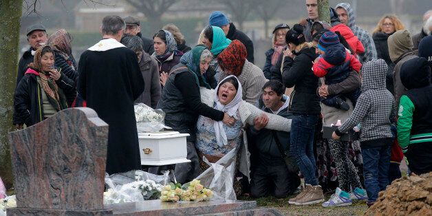 The mother of Maria Francesca, who died of sudden infant death syndrome, cries in front of the coffin of her baby during the funeral in Wissous, outside Paris, France, Monday, Jan. 5, 2015. Wissous offered a gravesite for the baby after the mayor of Champlan, where the child and mother lived, reportedly refused a burial plot. (AP Photo/Christophe Ena)