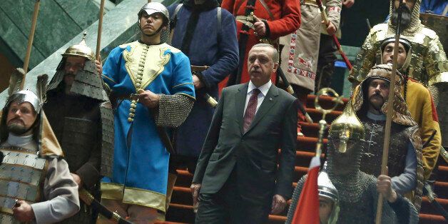 Turkish President Recep Tayyip Erdogan walks between the honor guards wearing historic Turkish warriors costumes before a ceremony for his Palestinian counterpart Mahmoud Abbas at his new presidential palace in Ankara, Turkey, Monday, Jan. 12, 2015. Abbas is in Turkey for a state visit.(AP Photo/Adem Altan, Pool)