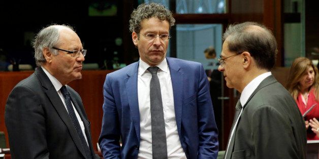 Maltese Finance Minister Edward Scicluna, left, talks with Dutch Finance Minister Jeroen Dijsselbloem, center, and Greek Finance Minister Gikas Chardouvelis, during the EU Finance Ministers meeting, at the European Council building in Brussels, Friday, Nov. 7, 2014. EU finance ministers were preparing Friday to hunt for a compromise in a row between Britain and Brussels over budget contributions, with billions of euros at stake. (AP Photo/Yves Logghe)