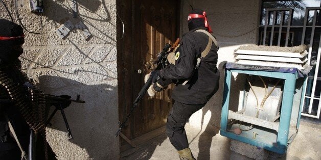 Pro-Iraqi government fighters, some belonging to the Iraqi Imam Ali Brigade, inspect houses during an operation to secure an area they seized from the Islamic State (IS) militants in Yathreb near Balad, about 75 kilometres (45 miles) north of Baghdad on December 29, 2014. Iraqi forces backed by Sunni tribes advanced on December 28 into the town of Dhuluiyah, strategically located on roads linking the eastern province of Diyala to Salaheddin province, north of Baghdad in a new attempt to push out