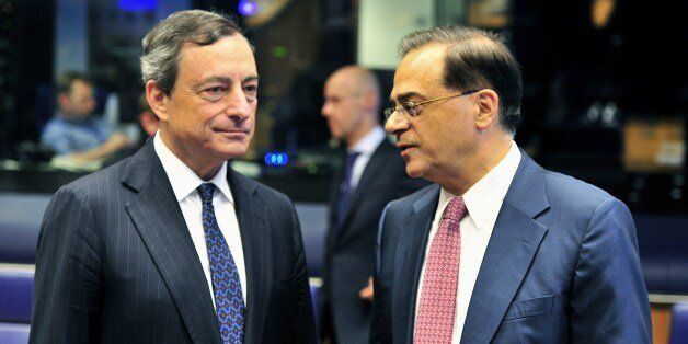 European Central Bank president Mario Draghi (L) and Greek Finance Minister Guikas Hardouvelis talk prior to a Eurogroup meeting on June 19, 2014 at the EU Headquarters in the Kirchberg Conference Centre in Luxembourg. The finance ministers of the EuroZone met in Luxembourg to review the program countries (Cyprus, Greece, Portugal, Ireland). They should give on this occasion the green light to the payment of a new tranche of aid for Cyprus. AFP PHOTO / GEORGES GOBET (Photo credit should r
