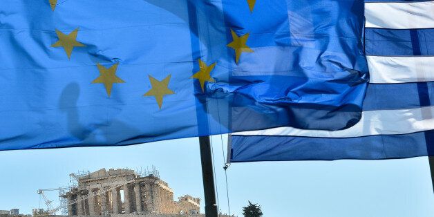 European Union flag and Greek flag wave in front of the Acropolis, in central Athens on June 16, 2012. The radical left's firebrand leader Alexis Tsipras at his final election rally in Athens, accused his main rival, conservative New Democracy leader Antonis Samaras, of defending German Chancellor Angela 'Merkel's Europe of the past.' 'We guarantee the Europe of the future,' he said. AFP PHOTO / ANDREAS SOLARO (Photo credit should read ANDREAS SOLARO/AFP/GettyImages)