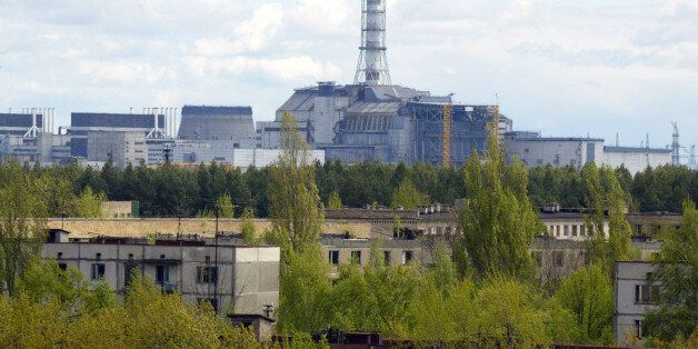 **** FILE ** This May 10, 2007 file photo shows a general view of empty houses in the town of Pripyat and the closed Chernobyl nuclear power plant in the background. Twenty-two years after the world's worst nuclear accident, work is under way to erect a new, safe confinement that officials hope would help solve at least one the many problems associated with Chernobyl, the risk of further contamination. (AP Photo/Efrem Lukatsky, File)