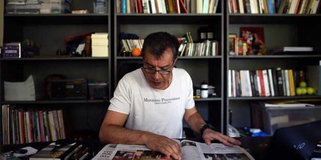 TO GO WITH AFP STORY : EU-ELECTION-GREECE-POLITICS BY JOHN HADOULISStavros Theodorakis, 50, leader of the new political party To Potami (The River), reads newspapers at his office in Athens on April 25, 2014. In a Greek society turned on its head by a six-year economic crisis, a 50-year-old former star journalist has become the country's newest political celebrity. In just two months, the startup To Potami is already ranked third in the polls ahead of May's European Parliament elections. Theodor