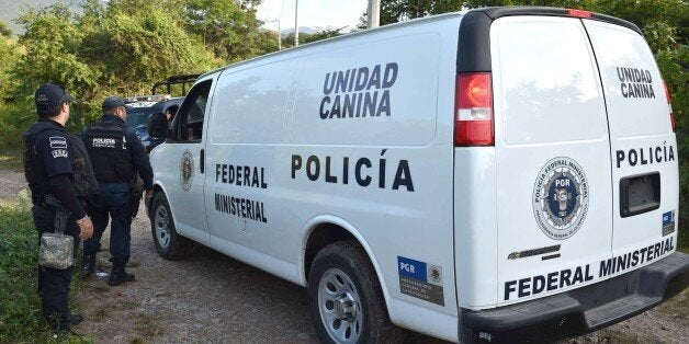 A vehicle of the federal police canine unit crosses the checkpoint on its way to the place where a new mass grave was found in the 27 de Setiembre neighborhood in Iguala, Guerrero state, Mexico on October 10, 2014. The case of 43 Mexican students missing since an attack by gang-linked police took another grim turn Thursday with the discovery of new mass graves where suspects said some were buried. Four new suspects took investigators to the site of the four pits, 200 kilometers (125 miles) south