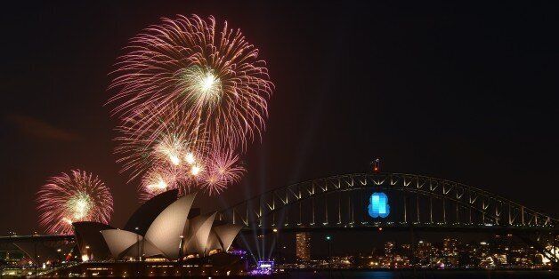 New Year's Eve fireworks erupt over Sydney's iconic Harbour Bridge and Opera House during the traditional early family fireworks show held before the main midnight event on December 31, 2014. AFP PHOTO / Saeed KHAN (Photo credit should read SAEED KHAN/AFP/Getty Images)