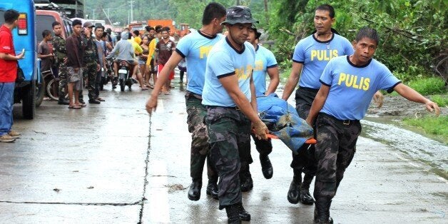 SAMAR, PHILIPPINES - 2014/12/30: Policemen recovered dead bodies of landslide victim. The storm, known as Seniang in the Philippines and Jangmi internationally, developed as a depression Saturday East of Mindanao, the country's main Southern island. According to reports, 31 people are dead, 10 are missing, thousands have been evacuated and standred travellers as it drifts west through the Philippines, unleashing torrents of rainfall that have led to deadly landslides and severe flooding. (Photo