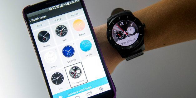 An exhibitor demonstrates an LG G Watch R smartwatch, manufactured by LG Electronics Inc., right, alongside an LG smartphone during the 2015 Consumer Electronics Show (CES) in Las Vegas, Nevada, U.S., on Wednesday, Jan. 7, 2015. This year's CES will be packed with a wide array of gadgets such as drones,connected cars, a range of smart home technology designed to make everyday life more convenient and quantum dot televisions, which promise better color and lower electricity use in giant screens. Photographer: David Paul Morris/Bloomberg via Getty Images