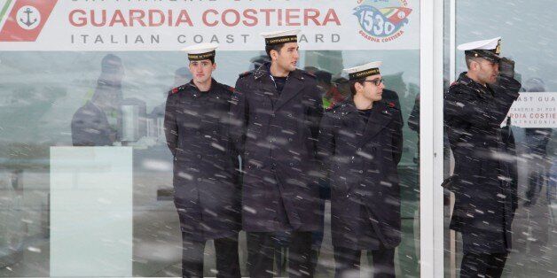 Italian Coast Guards wait for a Malta-registered cargo carrying some of the rescued passengers of the 'Norman Atlantic' ferry, as snow falls in the port of Manfredonia, southern Italy, on December 30, 2014. Ten passengers dead, dozens unaccounted for and no-one able to say with any certainty how many people were on board the Norman Atlantic when it burst into flames. A Greek ferry tragedy in the Adriatic turned into a murder mystery on December 30 as a fiasco over the accuracy of the passenger list added to questions over safety systems aboard. The maltese cargo Aby Jeannette with some of the rescued passengers aboard could not reach the port of Manfredonia due to bad weather, and was routed by the italian Coast Guards towards Taranto harbour. AFP PHOTO / CARLO HERMANN (Photo credit should read CARLO HERMANN/AFP/Getty Images)