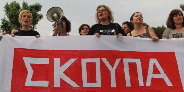 Laid-off former Finance Ministry cleaning staff, school teachers and school guards, shout slogans during a demo in the northern Greek port city of Thessaloniki, Tuesday, June 17, 2014. Hundreds of people took part in a solidarity protest, demanding that the government reinstate them in their jobs. Banner reads in Greek