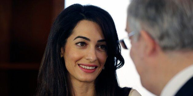 Lawyer Amal Clooney, left, speaks with Greek Culture Minister Kostas Tassoulas, during their meeting in Athens, Tuesday, Oct. 14, 2014. Lawyers Geoffrey Robertson and Amal Clooney arrived Monday on a four-day visit to meet government officials, including Prime Minister Antonis Samaras, and advise on Greece's quest to have the Parthenon Marbles returned to Athens. (AP Photo/Thanassis Stavrakis, Pool)