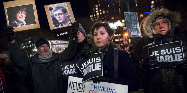 Julia Kite, center, holds a sign during a rally in support of Charlie Hebdo, a French satirical weekly newspaper that fell victim to an terrorist attack, Wednesday, Jan. 7, 2015, at Union Square in New York. French officials say 12 people were killed when masked gunmen stormed the Paris offices of the periodical that had caricatured the Prophet Muhammad. (AP Photo/John Minchillo)