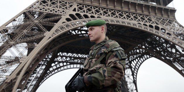 A French soldier patrols in front of the Eiffel Tower on January 7, 2015 in Paris as the capital was placed under the highest alert status after heavily armed gunmen shouting Islamist slogans stormed French satirical newspaper Charlie Hebdo and shot dead at least 12 people in the deadliest attack in France in four decades. Police launched a massive manhunt for the masked attackers who reportedly hijacked a car and sped off, running over a pedestrian and shooting at officers. AFP PHOTO / JOEL SAG