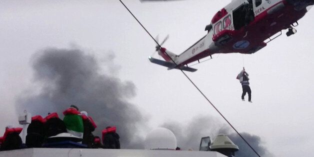 In this image taken from a Dec. 28, 2014 video and made available Wednesday, Dec. 31, 2014 a person is lifted from the deck of the Italian-flagged ferry Norman Atlantic by a rescue helicopter after it caught fire in the Adriatic Sea. More than 400 people were rescued from the ferry, most in daring, nighttime helicopter sorties that persisted despite high winds and seas, after a fire broke out before dawn Sunday on a car deck. Both Italian and Greek authorities have announced criminal investigati