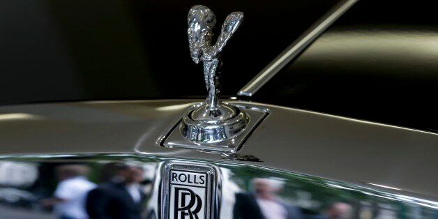 Pedestrians are reflected in the chrome work under The Spirit of Ecstasy on the front of a Rolls- Royce car, in a show room in London, Tuesday, July 8, 2014. Sales of luxury Rolls-Royce cars, which cost hundreds of thousands of dollars, have soared worldwide. The Britain-based manufacturer said Tuesday that global sales in the first half of the year were up 33 percent compared with the same period in 2013. (AP Photo/Kirsty Wigglesworth)