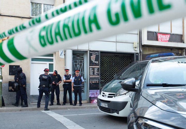 Agentes de la Guardia Civil y Mossos d'Esquadra, durante el registro de un domicilio en Sabadell (Barcelona).