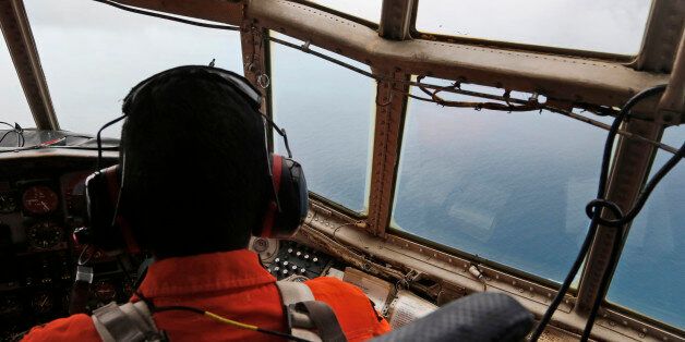 A crew of an Indonesian Air Force C-130 airplane of the 31st Air Squadron scans the horizon during a search operation for the missing AirAsia flight 8501 jetliner over the waters of Karimata Strait in Indonesia, Monday, Dec. 29, 2014. Search planes and ships from several countries on Monday were scouring Indonesian waters over which an AirAsia jet disappeared, more than a day into the region's latest aviation mystery. AirAsia Flight 8501 vanished Sunday in airspace thick with storm clouds on its
