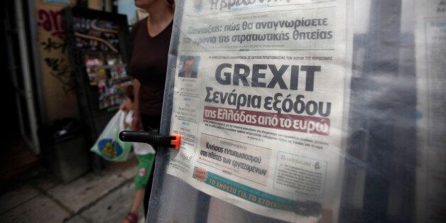 A pedestrian passes a 'Grexit' headline on a newspaper displayed at a street kiosk in Athens, Greece, on Thursday, May 24, 2012. European leaders tied their next steps on the financial crisis to the outcome of a bitterly contested election in Greece that may determine whether the 17-nation euro currency splinters. Photographer: Kostas Tsironis/Bloomberg via Getty Images