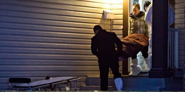 The body of a victim is carried out of a north Edmonton home in Edmonton, Alberta, Tuesday, Dec. 30, 2014. Nine people, including seven adults and two young children, were found dead at three separate crime scenes in what Edmonton's police chief on Tuesday called a