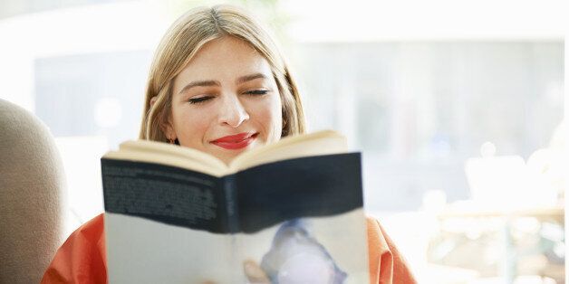 woman smiling and reading book