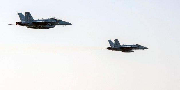 In this image released by the U.S. Navy on Friday, Dec. 5, 2014, an fighter jets conduct a high speed fly-by of the Nimitz-class aircraft carrier USS Carl Vinson (CVN 70) as the ship conducts flight operations in the U.S. 5th Fleet area of operations supporting Operation Inherent Resolve targeting Islamic State militants. (AP Photo/Mass Communication Specialist 2nd Class John Philip Wagner Jr., U.S. Navy)
