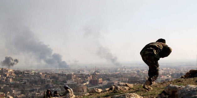 MOSUL, IRAQ - DECEMBER 22: Smoke rises as Islamic State of Iraq and Levant (ISIL) fighters burn tires to obstruct the sight of warcraft during clashes with Peshmerga forces in Sinjar district of Mosul, Iraq on December 22, 2014. Peshmerga forces stage attacks against ISIL to liberate ISIL occupied Sinjar. (Photo by Emrah Yorulmaz/Anadolu Agency/Getty Images)