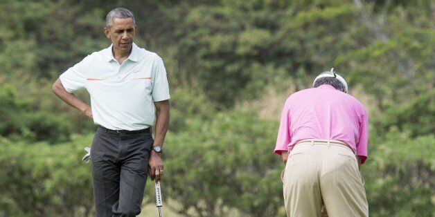 US President Barack Obama watches Malaysian Prime Minister Najib Razak putt as they play golf at Marine Corps Base Hawaii on December 24, 2014.. AFP PHOTO/Nicholas KAMM (Photo credit should read NICHOLAS KAMM/AFP/Getty Images)
