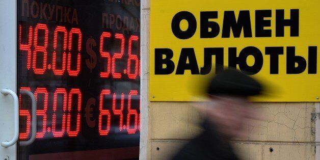 A pedestrian walks past a board listing foreign currency rates against the Russian ruble outside an exchange office in central Moscow on December 1, 2014. The ruble on December 1 slid to new lows of over 51 to the dollar and 65 to the euro, which gained more than two rubles in one day, Russian news agencies reported. AFP PHOTO / VASILY MAXIMOV (Photo credit should read VASILY MAXIMOV/AFP/Getty Images)