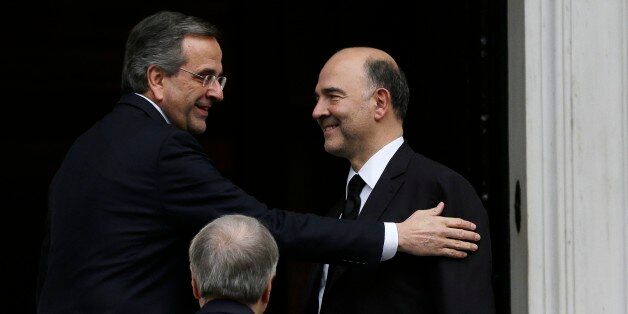 EU Commissioner for Economic and Financial Affairs Pierre Moscovici, right, arrives for talks with Greece's conservative Prime Minister Antonis Samaras, left, at his official residence in central Athens on Monday, Dec. 15, 2014. Moscovici is on a two-day visit to Athens, despite delayed negotiations between Greece and bailout lenders, ahead of voting that starts in parliament this week for a new Greek president, that is threatening to topple the government by the end of the month. (AP Photo/Thanassis Stavrakis)
