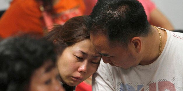 A relative of the passengers of AirAsia flight QZ8501 weeps as she waits for the latest news on the missing jetliner at a crisis center set up by local authority at Juanda International Airport in Surabaya, East Java, Indonesia, Sunday, Dec. 28, 2014. A massive sea search was underway for an AirAsia plane that disappeared Sunday while flying from Indonesia to Singapore through airspace possibly thick with dense storm clouds, strong winds and lightning, officials said. (AP Photo/Trisnadi)