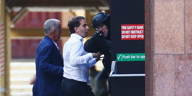 SYDNEY, AUSTRALIA - DECEMBER 15: A hostage is seen outside the Lindt Cafe, Martin Place on December 15, 2014 in Sydney, Australia. Police attend a hostage situation at Lindt Cafe in Martin Place. (Photo by Mark Metcalfe/Getty Images)